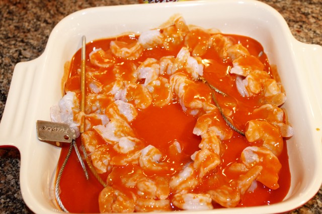 Skewer shrimp and marinate with buffalo sauce