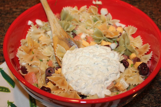 Add lemon aioli dressing to pasta mixture