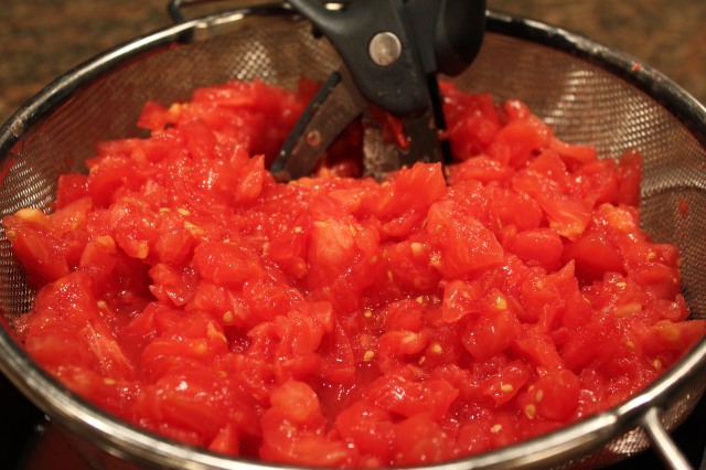 Chop tomatoes in a colander