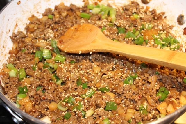 Add sesame seeds, green onions, etc. to beef mixture
